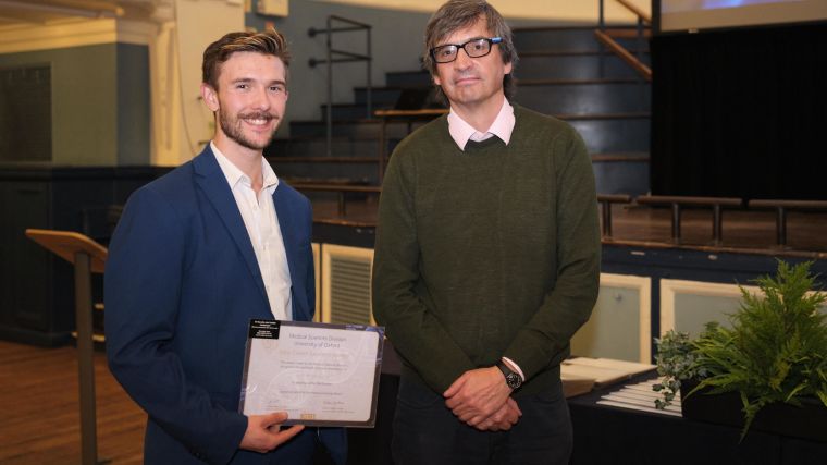 Olly Featherstone receiving a certificate from Professor Gavin Screaton, Head of Division.
