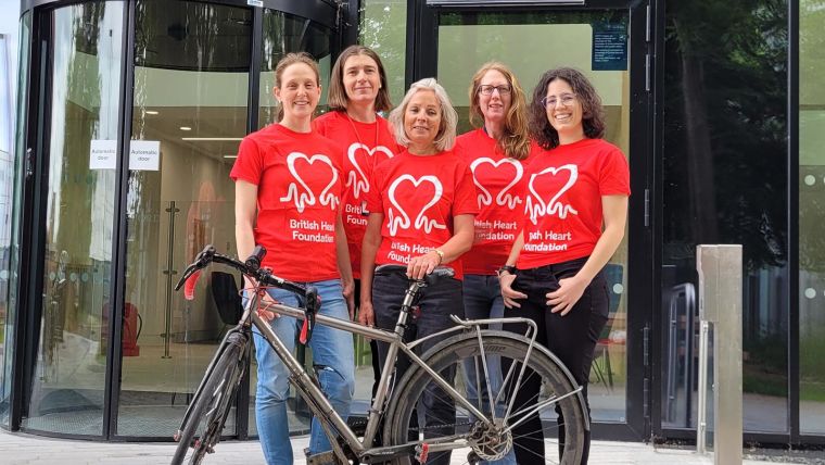 The team posing in BHF T-shirts with a bike